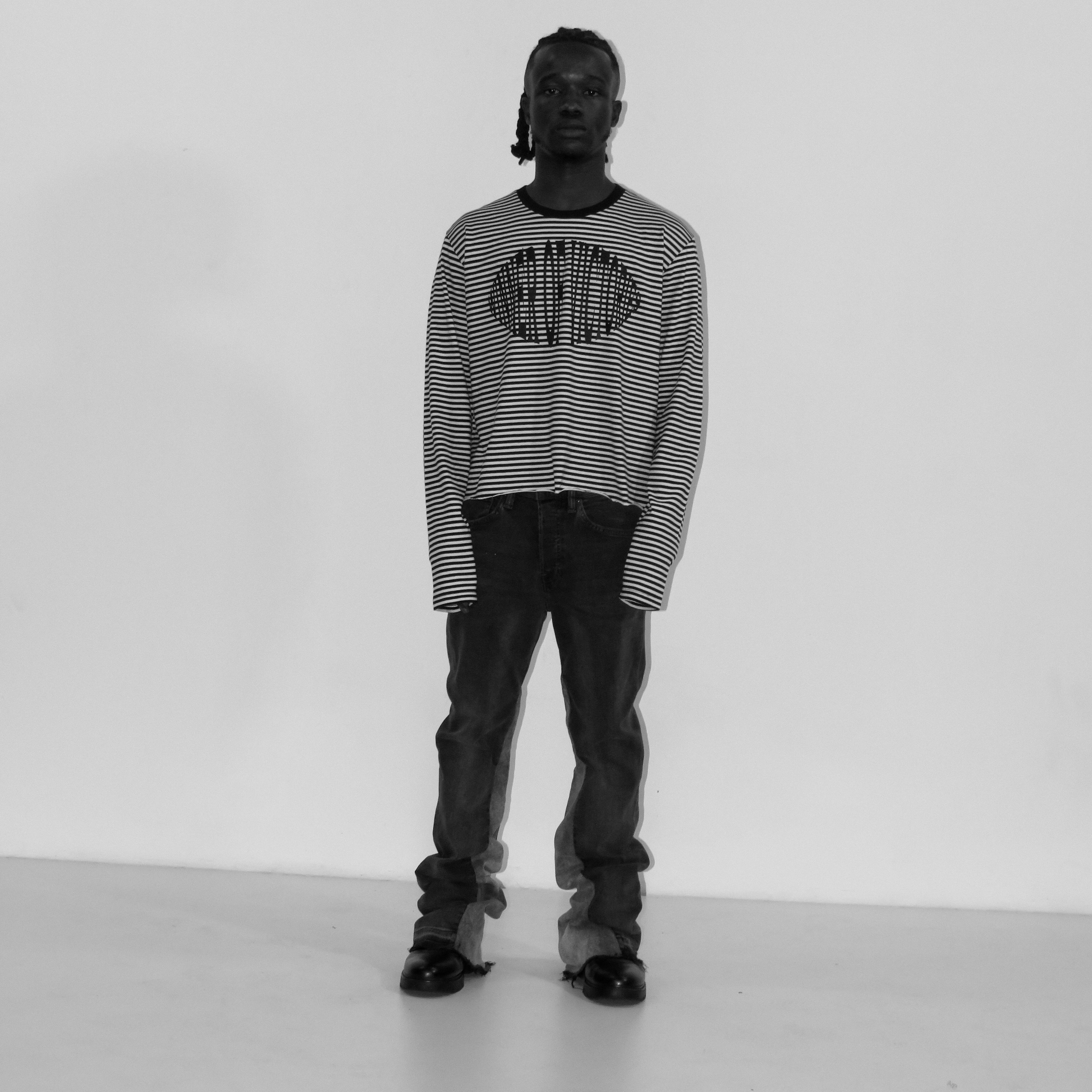 Person wearing a striped sweater with a logo on a white background