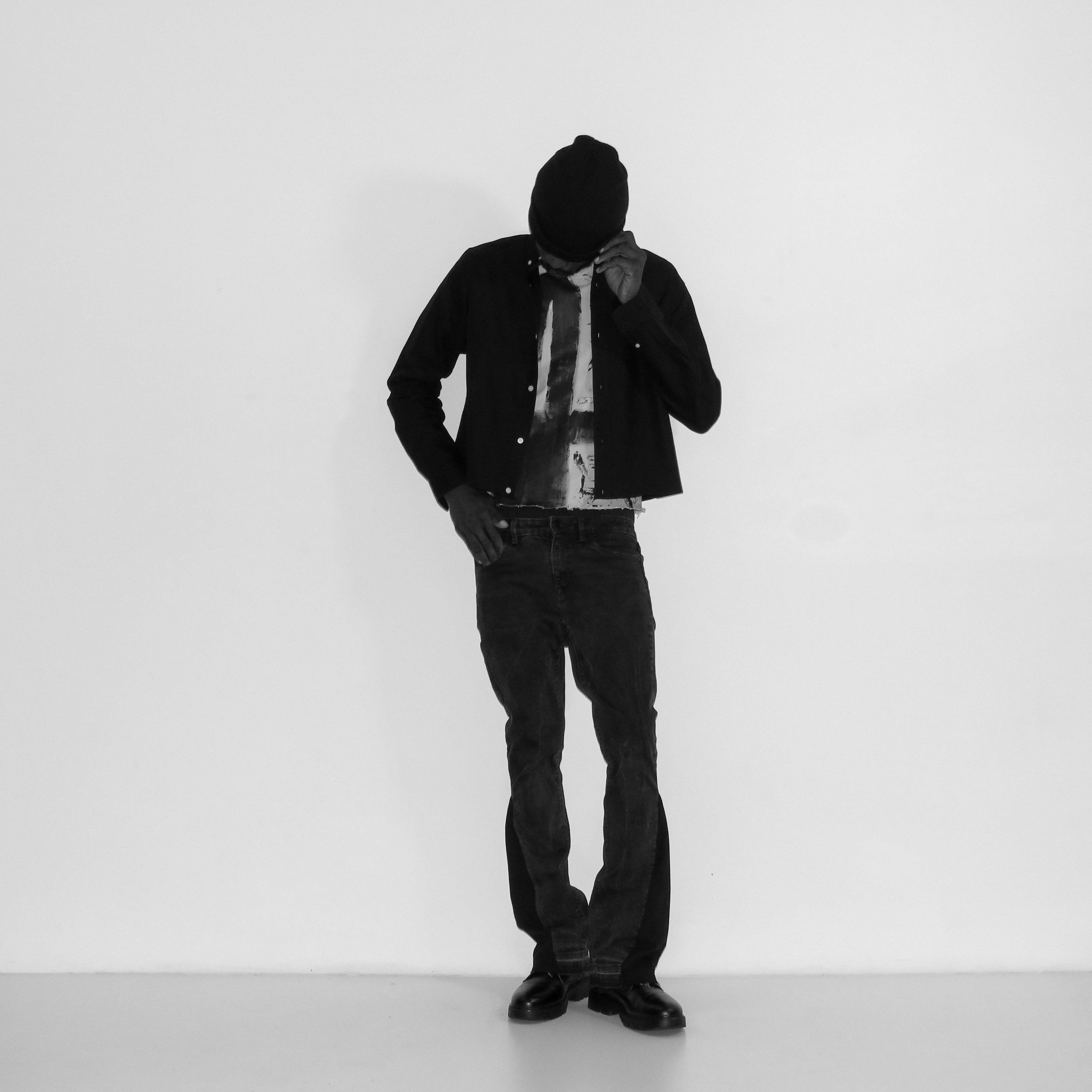 Person wearing a black jacket and pants on a white background
