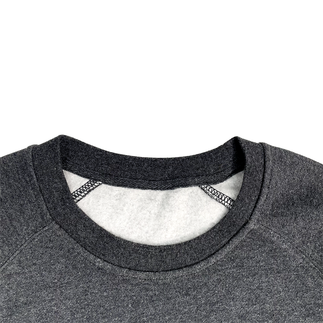 Close-up of a gray sweatshirt collar with a white shirt underneath on a white background
